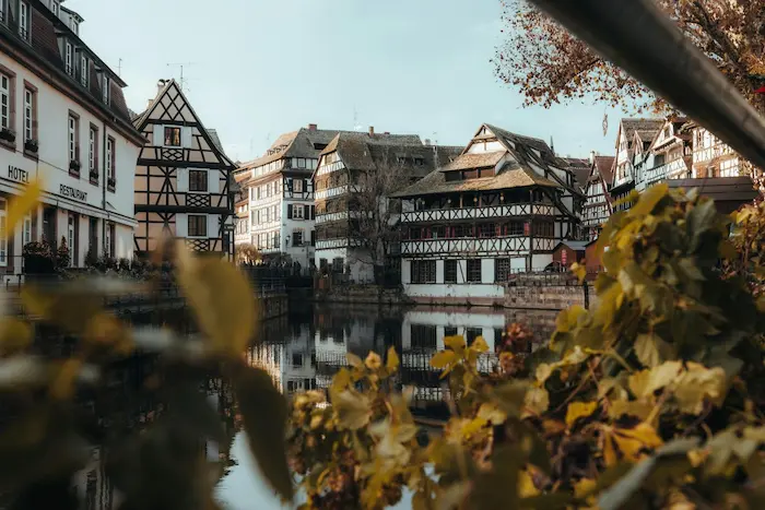 Vue sur maisons à colombages le long du canal, illustrant l’attrait d’un achat d’appartement neuf en centre-ville.