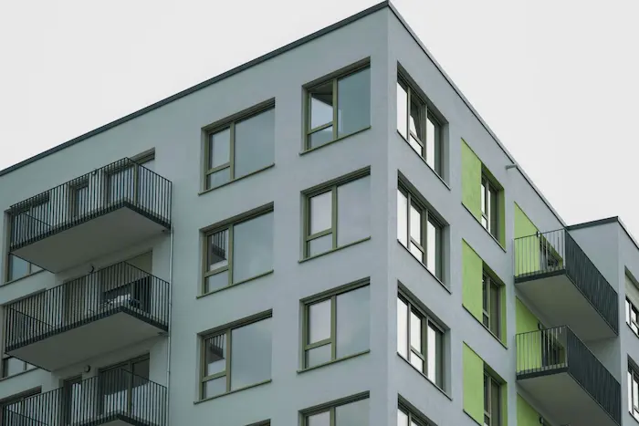Façade moderne d’un immeuble résidentiel illustrant l’attrait d’un achat d’appartement neuf avec design contemporain et balcons privés.