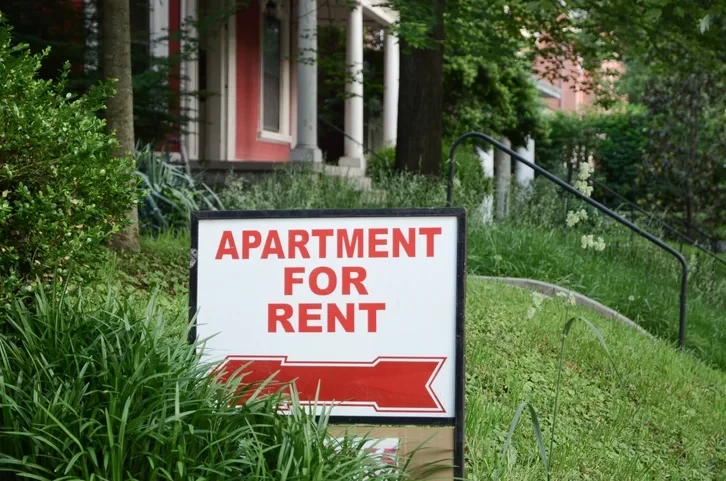 Une plaque annonçant la mise en location appartement Bordeaux, placée devant un bien immobilier