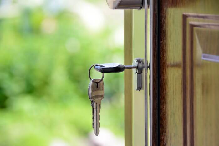 Une clé insérée dans une serrure de porte, représentant l'accès à la propriété. Cette image symbolise l'importance de l'indicateur des prix immobiliers dans le processus d'acquisition d'un bien immobilier, reflétant les fluctuations du marché et les décisions d'investissement.