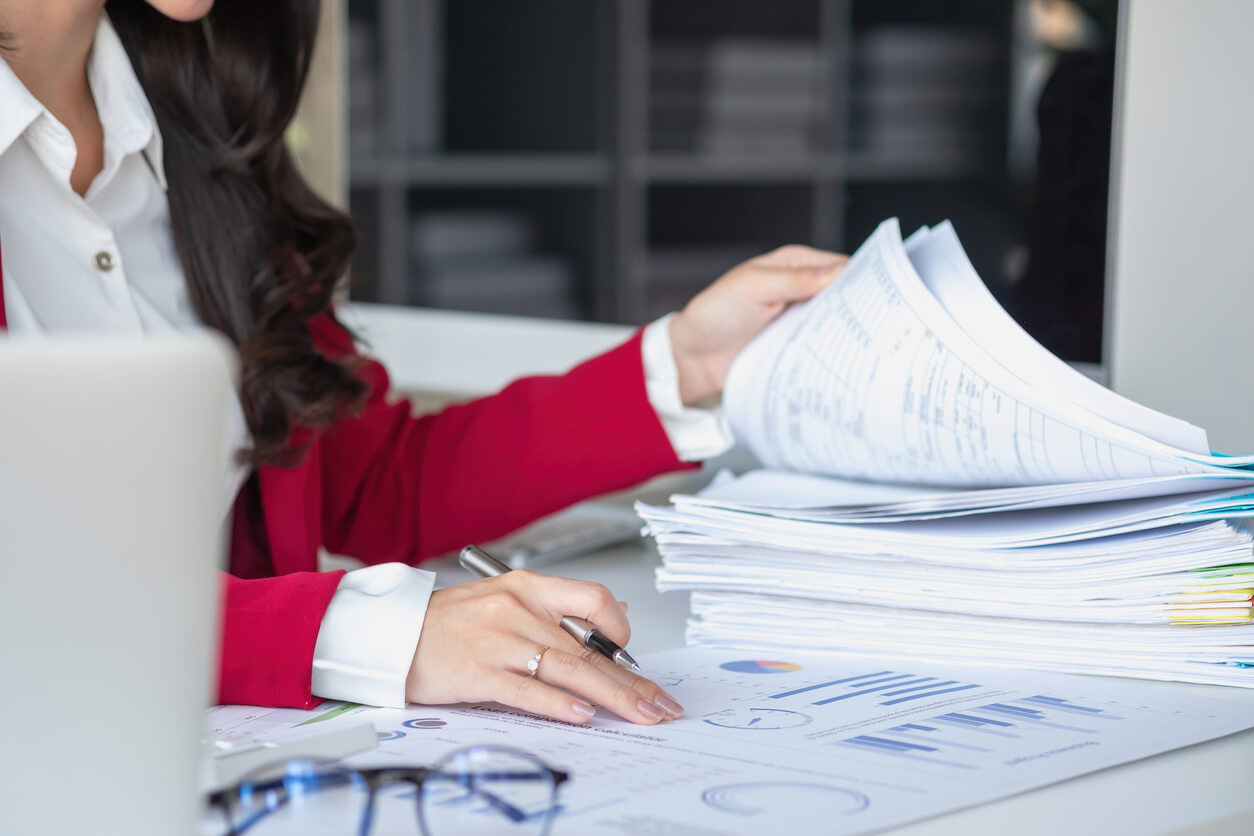 Femme en train de traiter des dossiers administratifs pour dissoudre une SCI gratuitement, en respectant les démarches légales et les procédures de liquidation.