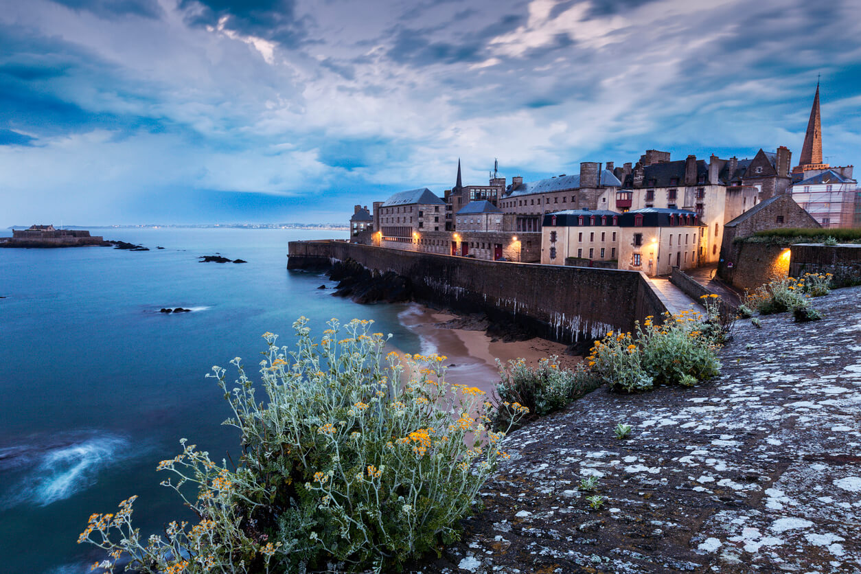 Vue sur les remparts de Saint-Malo au crépuscule, un lieu emblématique offrant un fort potentiel pour un investissement locatif Saint-Malo grâce à son attrait touristique