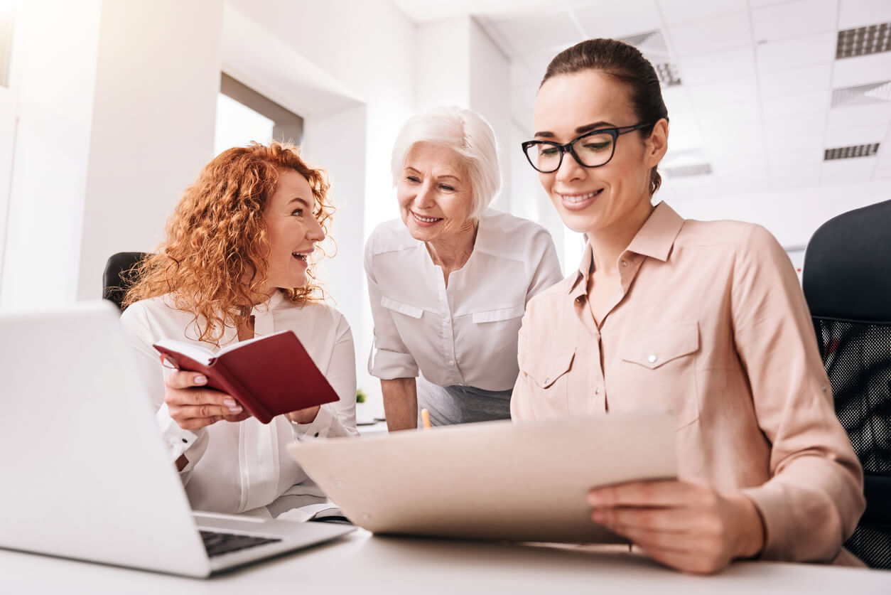 Monter une SCI pour acheter : des femmes échangent autour de documents financiers et de leur ordinateur pour préparer l'acquisition d'un bien immobilier en SCI.