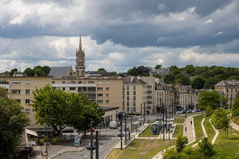 Vue sur la Caen, avec de nombreux biens immobiliers en fond. L'option de la location appartement Caen est diversifiée.