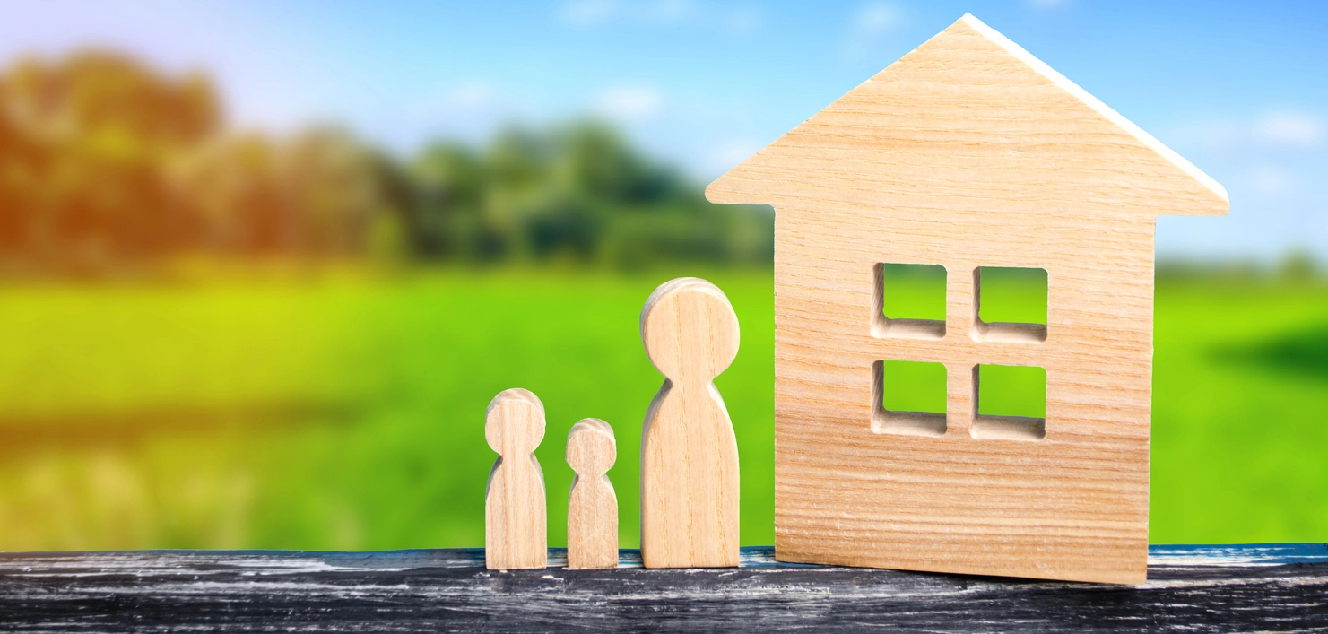 Maquette en bois d'une maison individuelle avec figurines représentant une famille. Illustration parfaite pour les projets immobiliers, nue propriété et usufruit ou la vie de famille