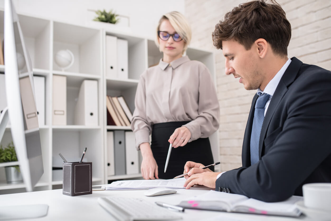 Image de deux personnes dans un bureau, discutant des stratégies pour maximiser la rentabilité et limiter les risques d'un investissement SCPI à crédit, avec des graphiques et des documents financiers sur la table.