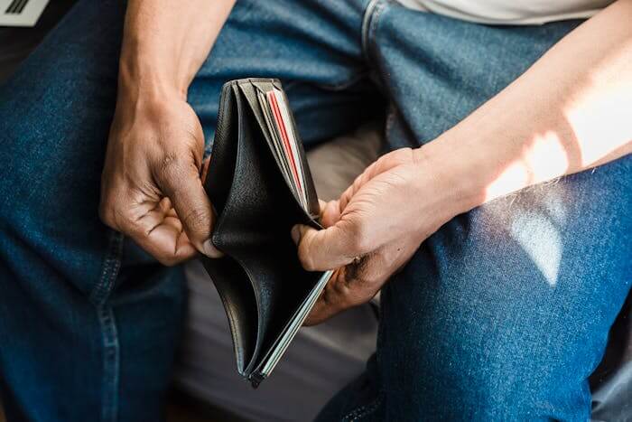 Une personne tenant son portefeuille dans ses mains. Elle n'a aucun centime et souhaite investir dans l'immobilier sans apport.