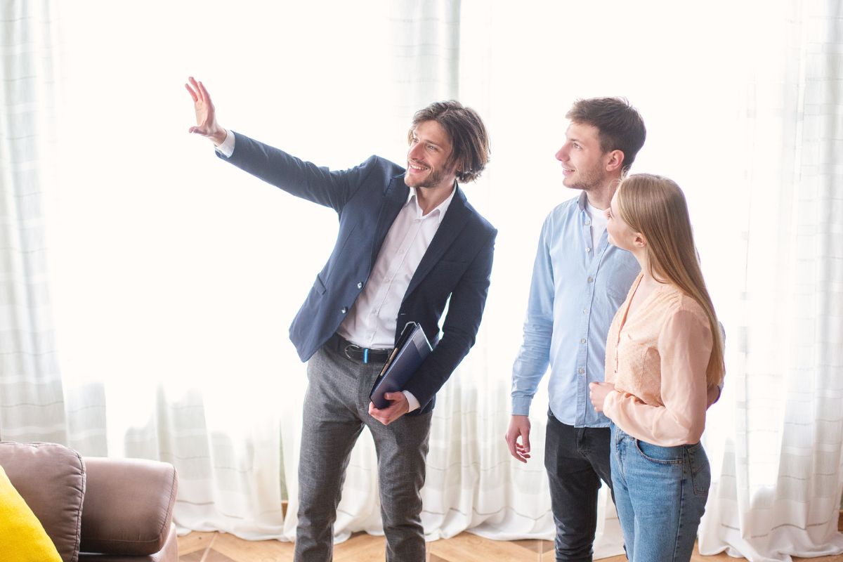 Un couple discute avec un expert LMNP pour se conformer à la liste des meubles obligatoires, afin d'assurer la conformité et le succès de leur location meublée.