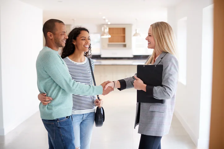 Couple visitant une location appartement Dijon avec un professionnel de l'immobilier, en se serrant la main