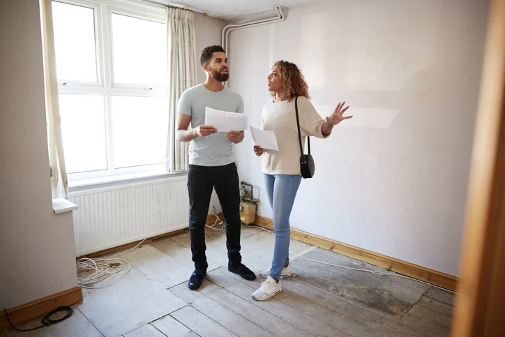 Un couple à l'intérieur d'une maison, entrain de vérifier les caractéristiques de celle-ci dans le cadre d'une location particulier à particulier appartement