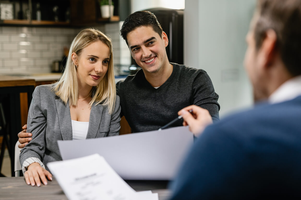 Trois personnes discutant l'avantage d'acheter un bien immobilier via une SCI familiale.