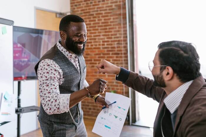 Photographie de deux investisseurs souriants, exprimant leur satisfaction et leur bonheur grâce à un cash flow positif. Leur joie reflète le succès de leurs investissements et la prospérité financière qu'ils ont atteinte.