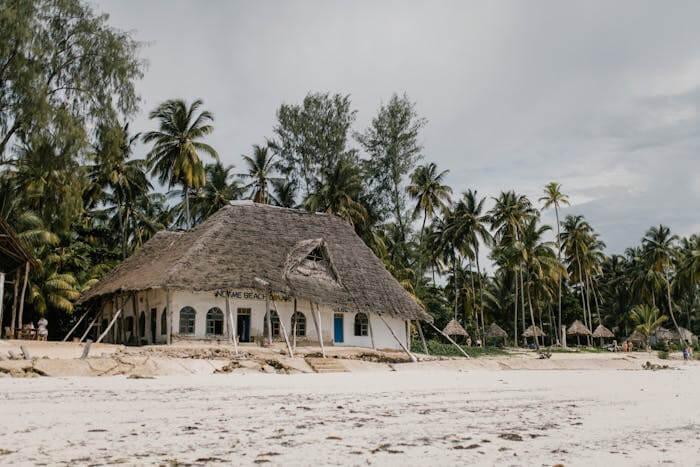 Photo d'une maison ancienne à rénover à Bali qui se trouve à la plage. Cette maison est entourée de cocotier.